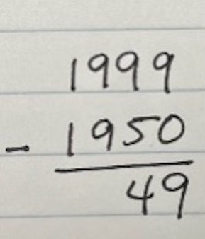 A handwritten math problem shows that 1999 minus 1950 is 49.