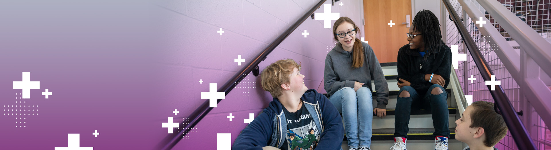 Students sitting on stairs interacting.