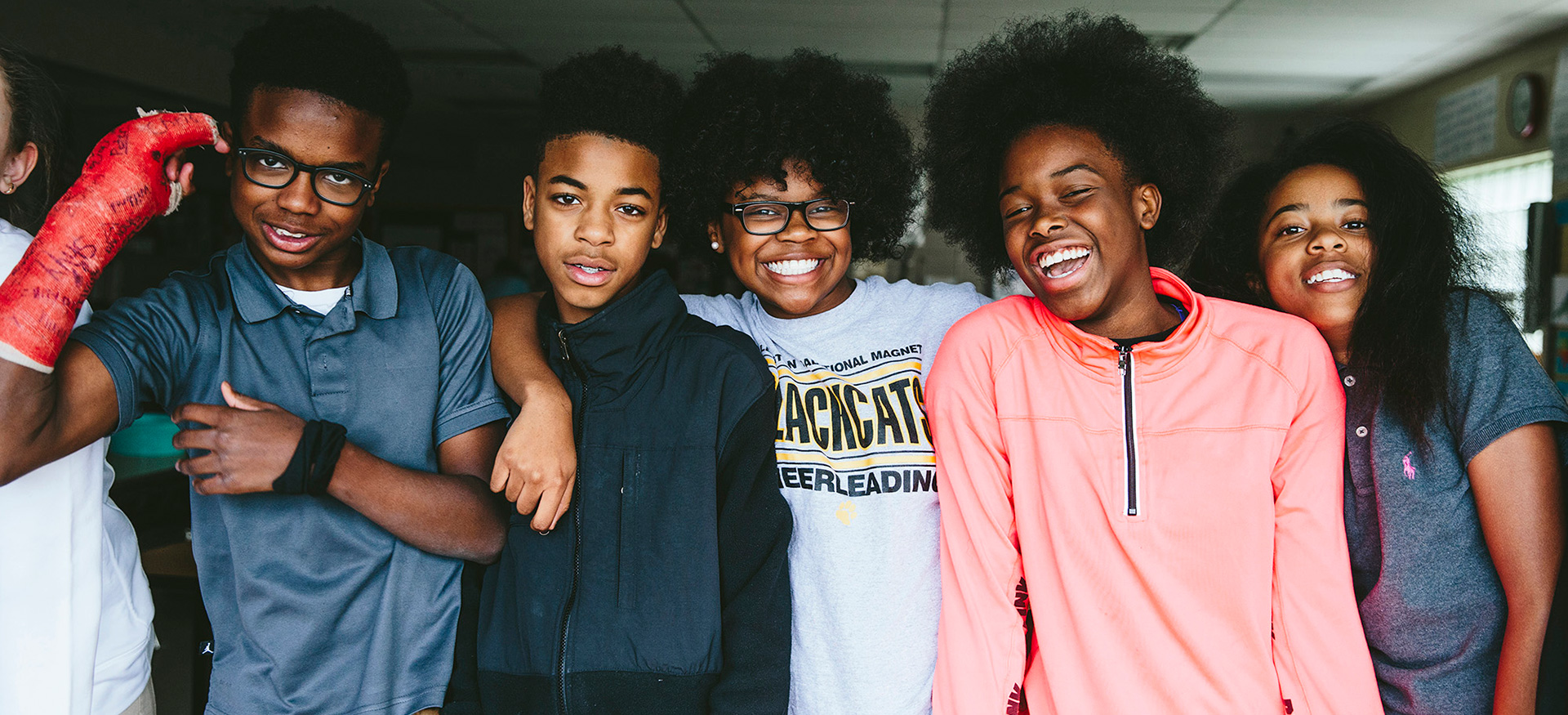 Group of students looking at the camera smiling and laughing.