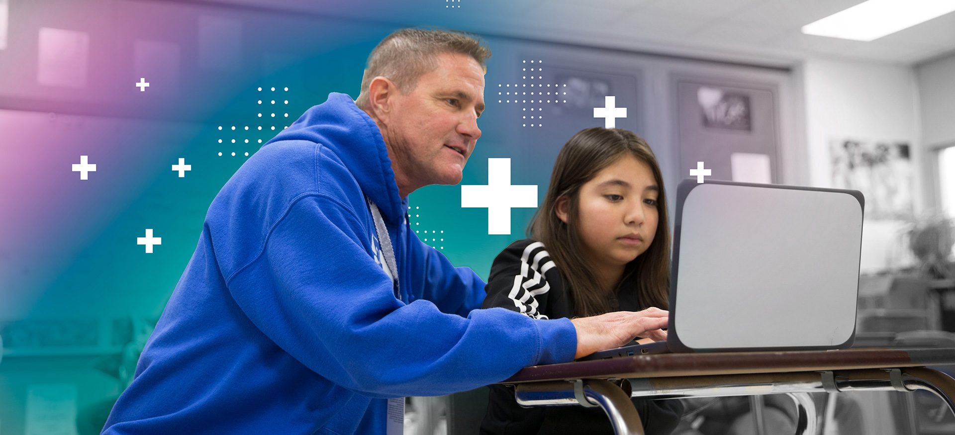 Classroom teacher assisting a student on a computer.