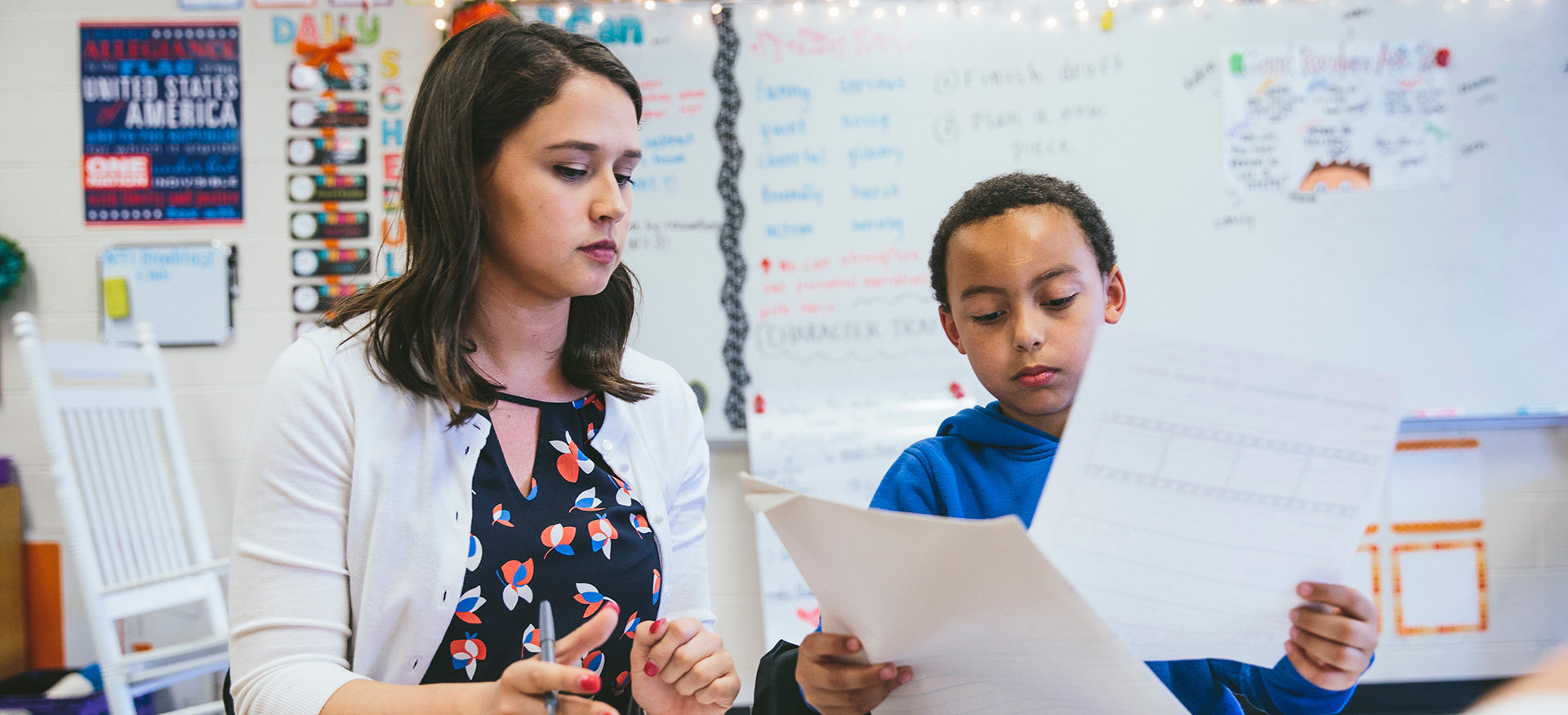 Young student discussing an assignment with their teacher.